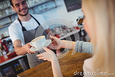 Tilt shot of barista serving coffee to woman at cafe Stock Photo