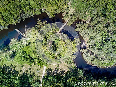 Timber bridge over winding creek Stock Photo