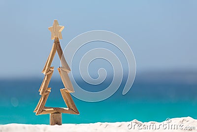 Timber Christmas tree in sand on the beach Stock Photo