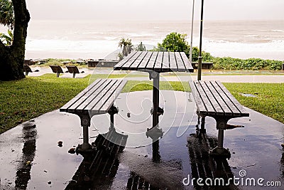 Timber Outdoor Dining By The Sea On a Rainy Day Stock Photo