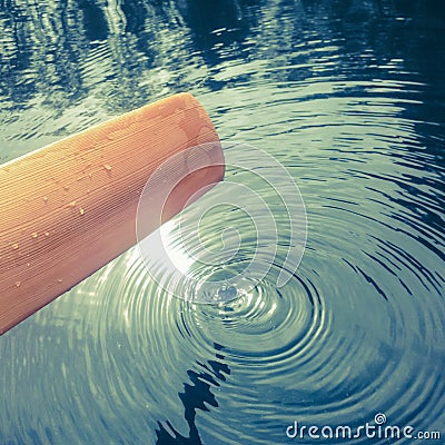 Timber wood greenland kayak paddle with water ripples and circle Stock Photo