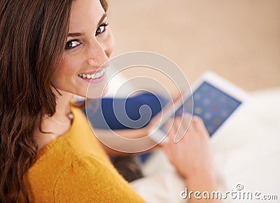 Time catch up with some friends. a gorgeous young woman using a digital tablet indoors. Stock Photo