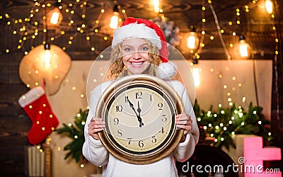 Time for celebration. Few minutes left. New year countdown. Midnight concept. Make wish. Happy emotional girl Santa hat Stock Photo