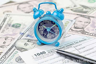 Time or deadline for yearly tax submission concept, miniature small retro alarm clock with pen on 1040 US individual income tax Stock Photo