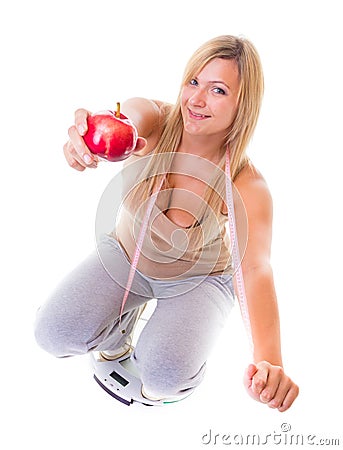 Time for diet slimming. Woman on scales apple measuring tape Stock Photo