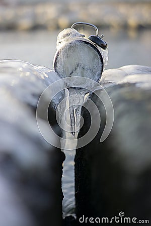 Time frozen alarm clock in ice on the beach between two rocks Stock Photo