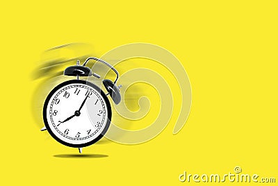 Retro black alarm clock alerting at seven o`clock on yellow background. Stock Photo