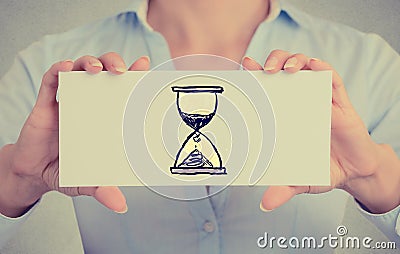 Time management concept. Woman hands card with sand clock sign Stock Photo