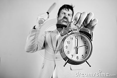 Time management and discipline. Discipline and sanctions. Boss aggressive face hold alarm clock. Destroy or turn off Stock Photo