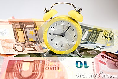 Time is money. European estimate of your time. Evro, alarm clock, and European paper money, on a white background. Business Stock Photo