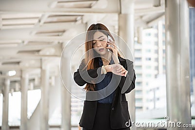 Time out concept. Urgent work, business woman seeing wrist watch and using mobile phone before meeting. Smart woman check the Stock Photo