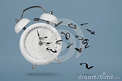 Time is running out. White alarm clock with flying numbers as a symbol of lost time. The concept of time is running out Stock Photo