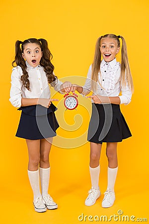 It is time. School schedule. Schoolgirls and alarm clock. Children school pupils. Knowledge day. School time. Surprised Stock Photo