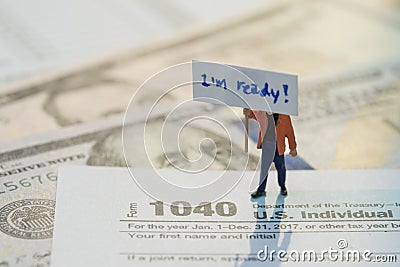 Time for tax concept, miniature figurine holding sign I`m ready with pen on 1040 US individual income tax filling form Editorial Stock Photo