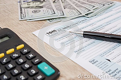 Time for Taxes, Federal Form 1040 with Pen, Dollars and Calculator, Office Desk. Paperwork. Editorial Stock Photo