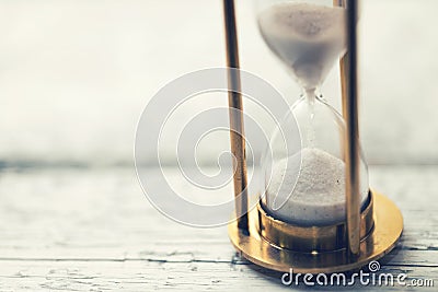 Time is ticking - hourglass on the table with copy space Stock Photo