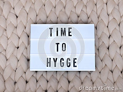 TIME TO HYGGE word on lightbox on knit background. Cozy compozition. Knit background. Stock Photo