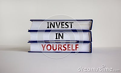 Time to invest in yourself. Books with text `invest in yourself` on beautiful white background. Business and growth concept. Cop Stock Photo