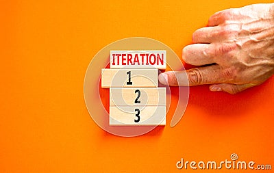 Time to iteration 1 symbol. Concept word Iteration 1 2 3 on wooden block. Businessman hand. Beautiful orange table orange Stock Photo