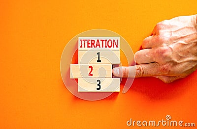 Time to iteration 2 symbol. Concept word Iteration 1 2 3 on wooden block. Businessman hand. Beautiful orange table orange Stock Photo