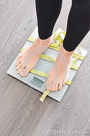 Time to lose kilograms with woman feet stepping on a weight scale Stock Photo