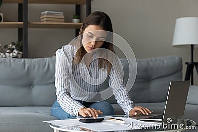 Young lady flat owner engaged in housekeeping at home office Stock Photo