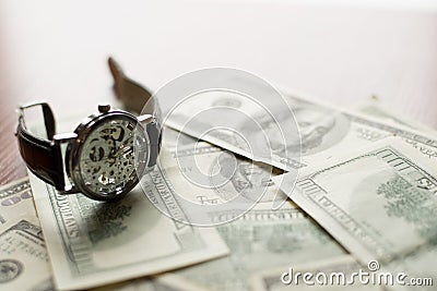 Time to pay - 100 dollars banknote and classic watch with Roman numerals Stock Photo