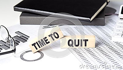 TIME TO QUIT - text on a wooden block with chart and notebook Stock Photo