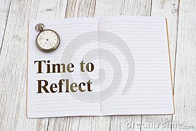 Time to reflect with a ruled line journal notepad with pocket watch on weathered desk for writing or journaling Stock Photo