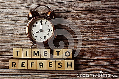 Time To Refresh alphabet letter with alarm clock on wooden background Stock Photo