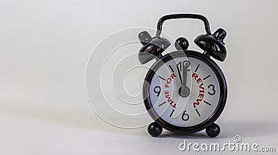 Time to review concept. Beautiful black alarm clock with words `time to review`. White table. Beautiful white background. Copy Stock Photo
