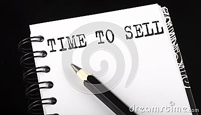 TIME TO SELL written text in small notebook on a black background Stock Photo