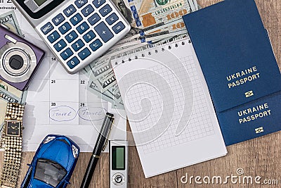 passport, money camera watch, calculator, glasses, calendar toy car on wooden table. Stock Photo