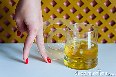 Time of whiskey. A glass of whiskey and a woman`s hand. Stock Photo