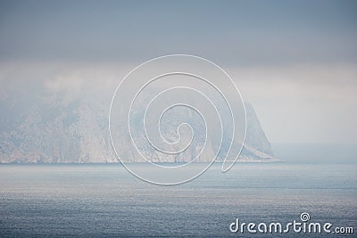 Timelapse of fluffy clouds moving in dark cloudy sky over calm sea and volcanic rocky shores. Abstract aerial nature Stock Photo