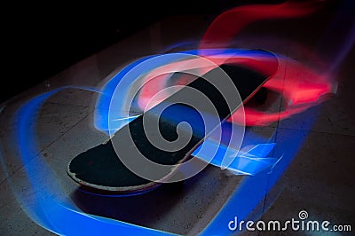 Timelapse shot of a skateboard with colorful light effects Stock Photo