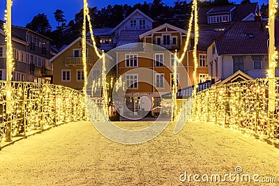 A timeless holiday scene in Norway's charming Town with festive illumination on the bridge. Stock Photo