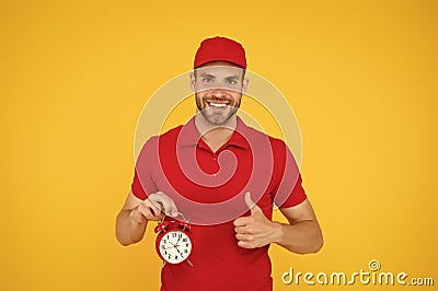 Timeliness guarantee. Promptness and punctuality. Delivery time. Delivery courier with clock. Delivery man holding clock Stock Photo