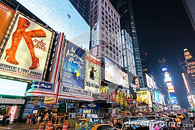 Times Square at night featuring lighted billboards of the broadway best show Editorial Stock Photo