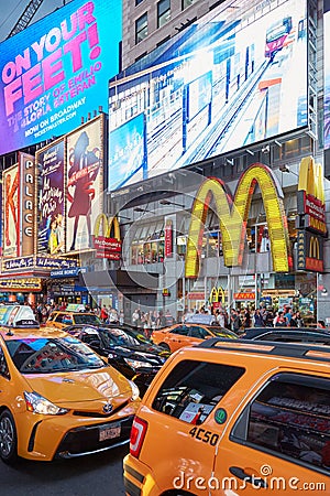 Times Square show billboards with people, yellow taxi traffic at night in New York Editorial Stock Photo