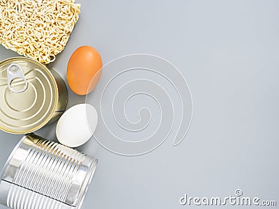 Tin cans, macaroni, eggs on a gray background, copispace, mock up. Stocks of fast food and long-term storage during the Stock Photo