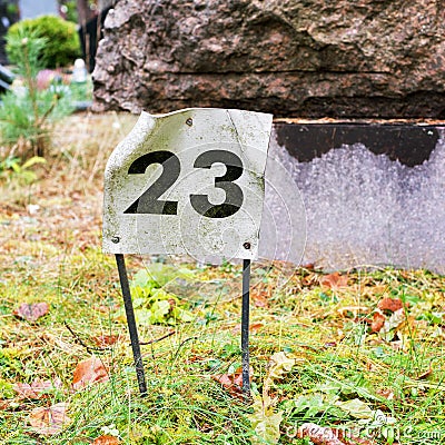 Plate with a number 23 sticked into the ground. Stock Photo