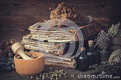 Tincture bottles, bunches of healthy herbs, stack of antique books, mortars, sack of medicinal herbs. Herbal medicine. Stock Photo