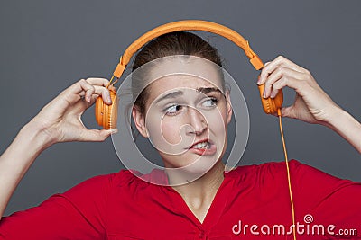 Tinnitus headphones concept for dubious 20s girl Stock Photo