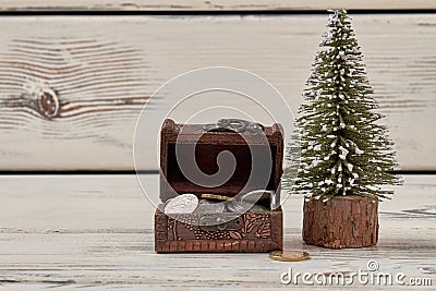 Tiny jewelry box with coins and christmas tree. Stock Photo