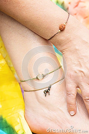 Tiny jewelry on female hand and leg Stock Photo