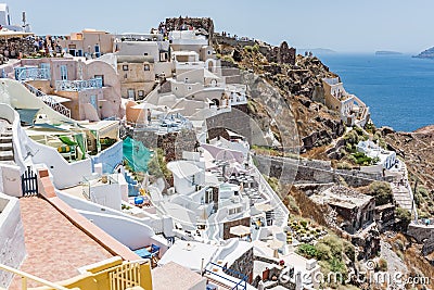 Tiny little white houses, hotels and long stairway to the harbour in the Oia village at Santorini, Greece. Editorial Stock Photo