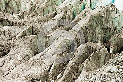 Tiny man walks expansive alpine glacier icefield Stock Photo