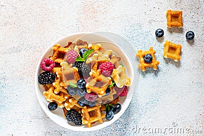 Tiny Mini waffles waffles with berries in a white bowl Stock Photo