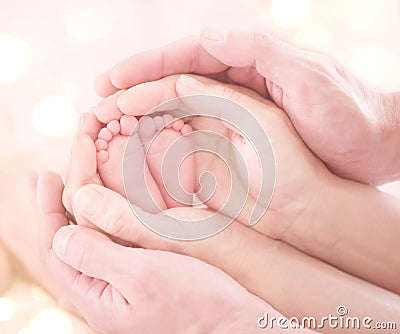 Tiny newborn baby`s feet in parent`s hands closeup. Happy family Stock Photo